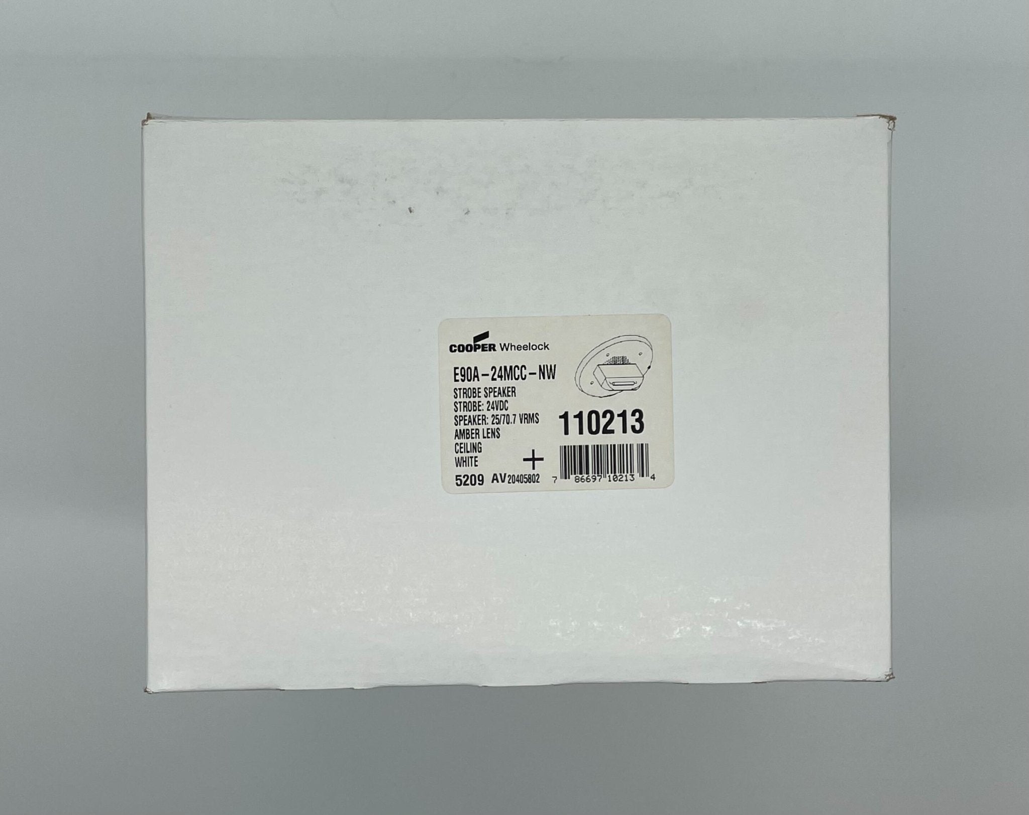 Eaton Wheelock E90A-24MCC-NW speaker strobe with white housing and black mounting plate, designed for fire alarm notification systems