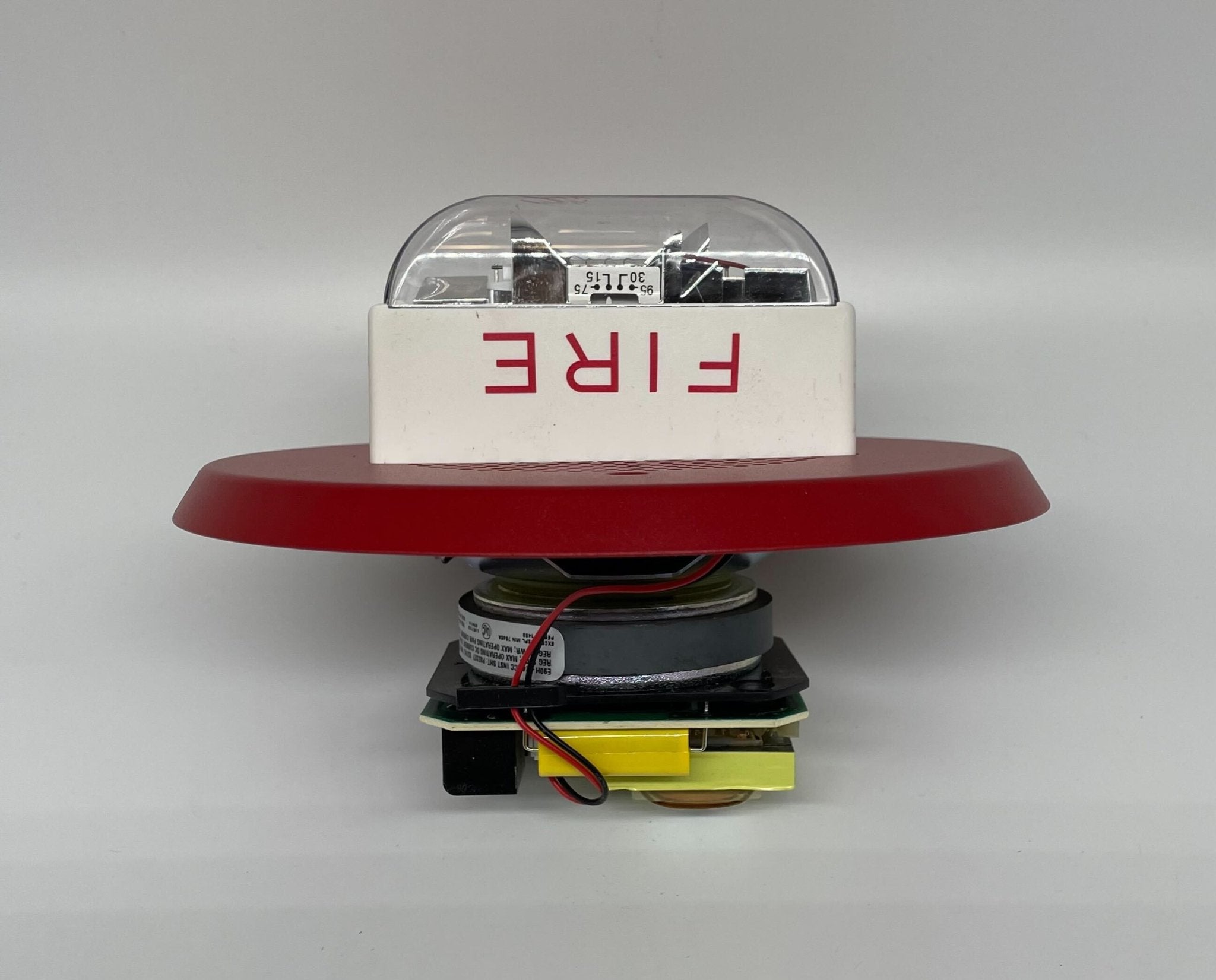 Eaton Wheelock E90H-24MCC-FR speaker strobe with red lens and mounting hardware, used for fire alarm notification.
