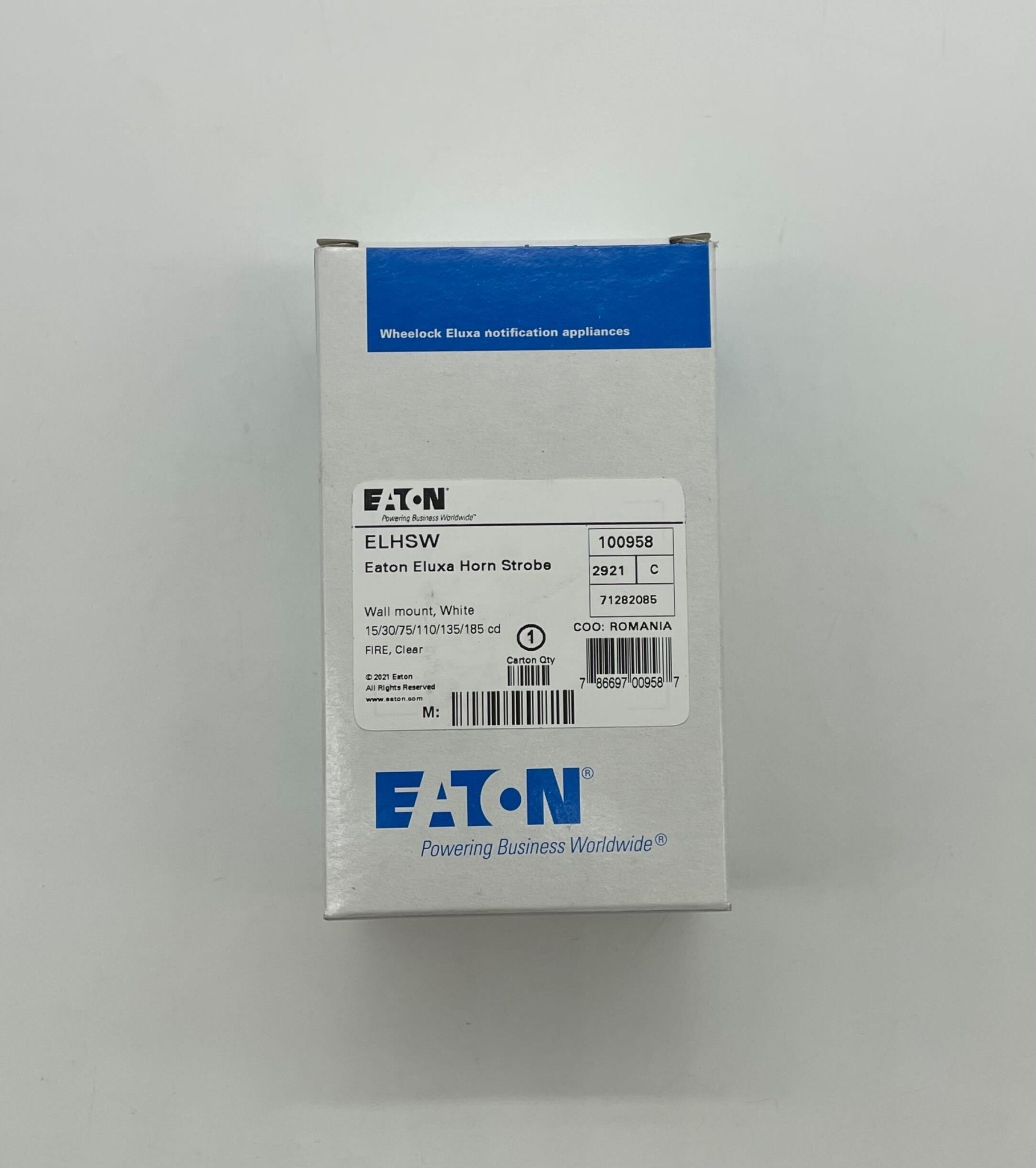 Eaton Wheelock ELHSW horn strobe alarm with yellow housing mounted on wall for fire safety alert system.