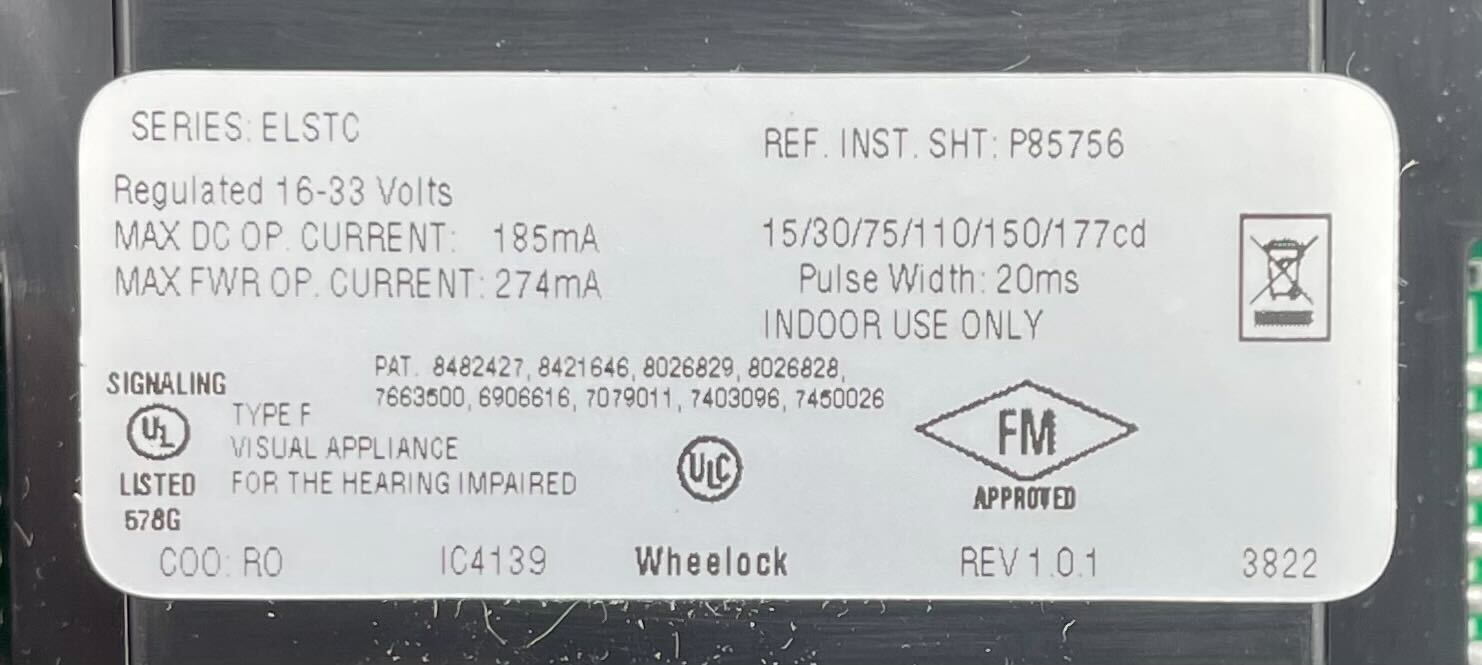 Eaton Wheelock ELSTWC strobe light with clear lens and mounting bracket, designed for emergency signaling and alert systems.