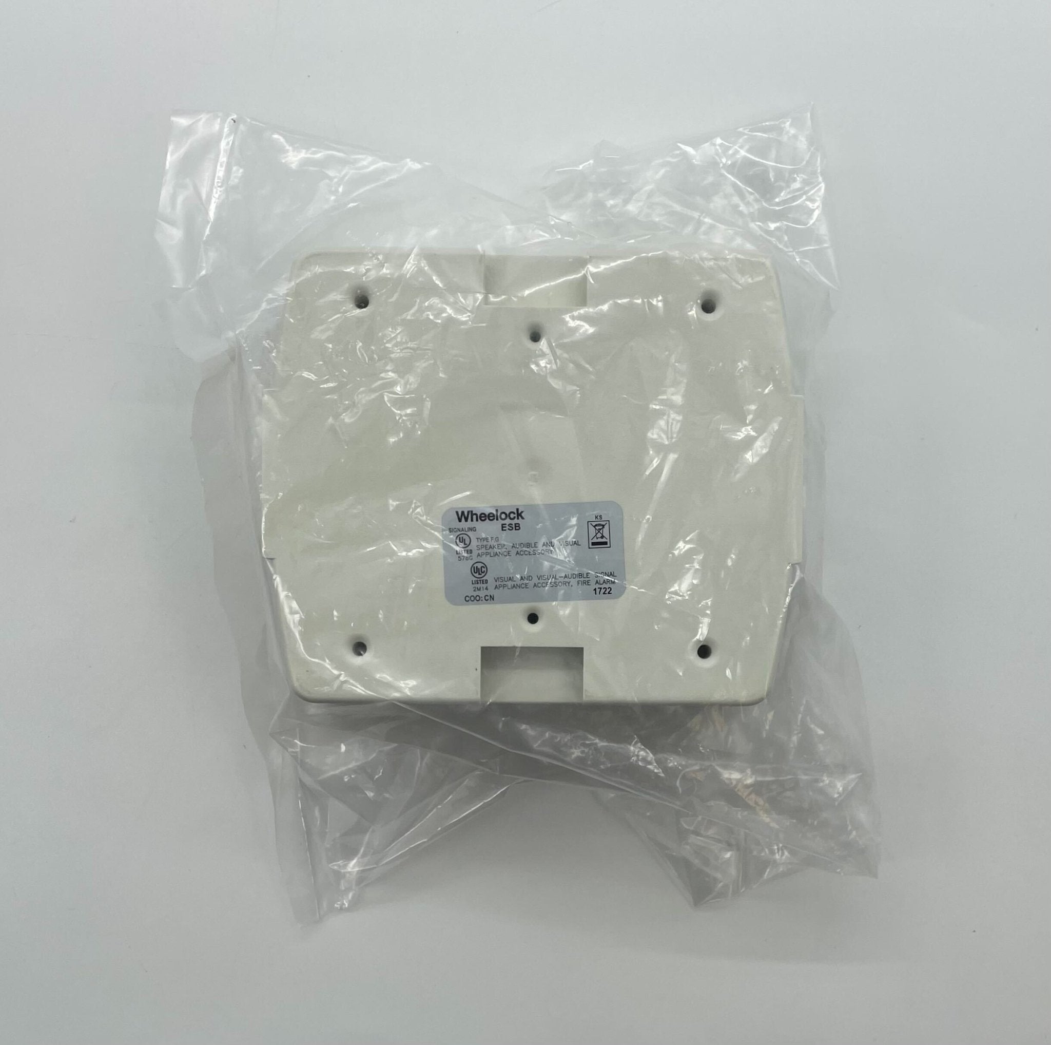Eaton Wheelock ESBW fire alarm with red alarm bell and mounting bracket, installed on wall for emergency alert system.