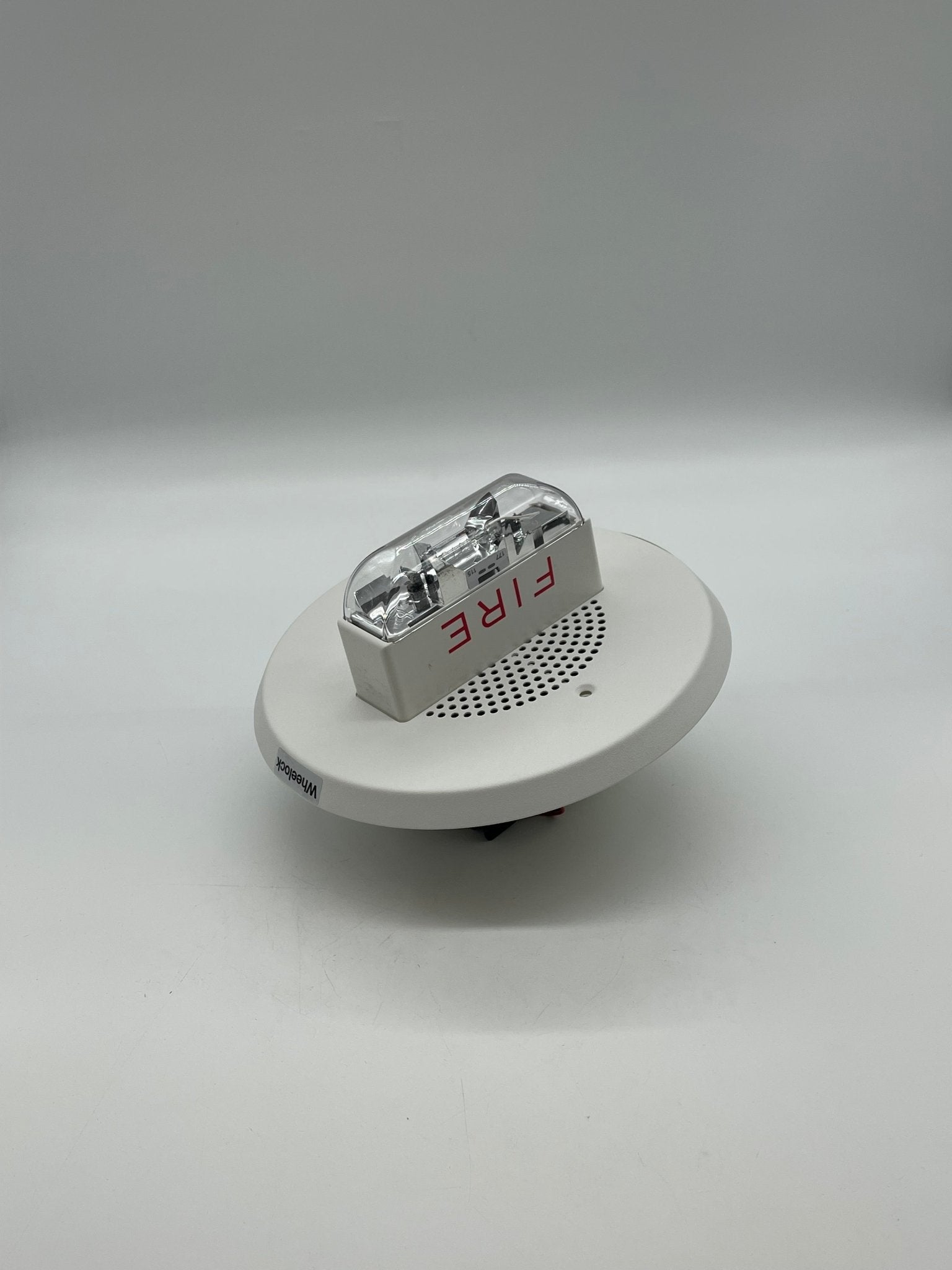 Eaton Wheelock ET90-24MCCH-FW speaker strobe with red casing and mounting bracket, designed for emergency notification systems.