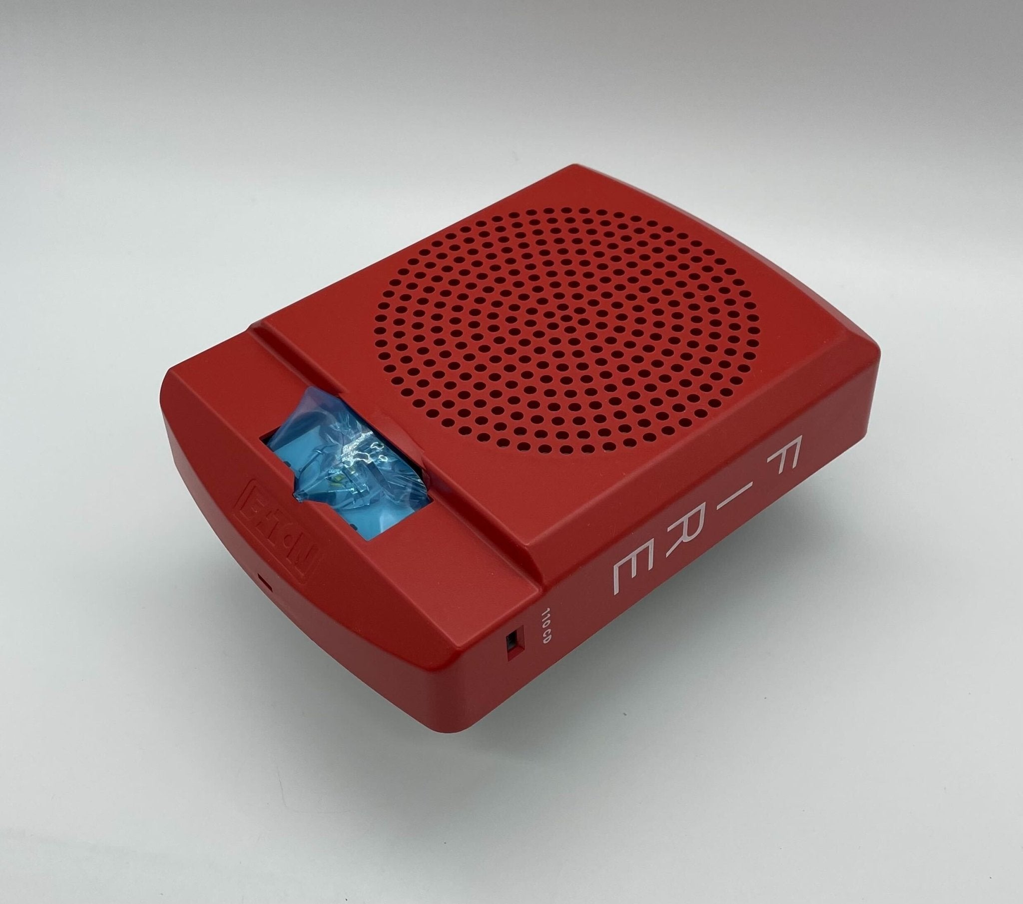 Eaton Wheelock LFHSKR3 horn strobe with red housing and mounting base, designed for emergency signaling and alert systems.
