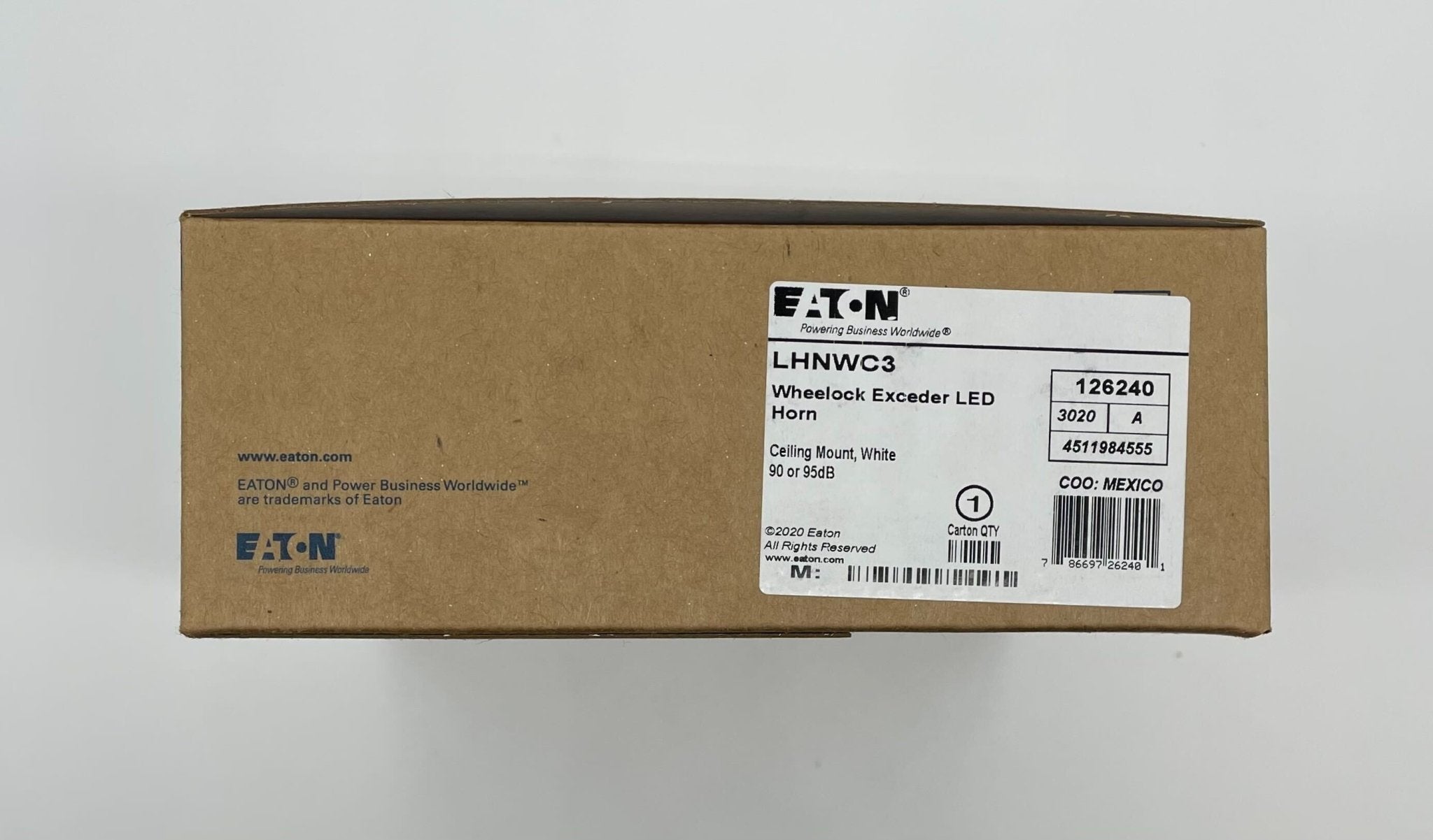 Eaton Wheelock LHNWC3 fire alarm with horn/strobe in white, mounted on wall, for building safety alert systems.