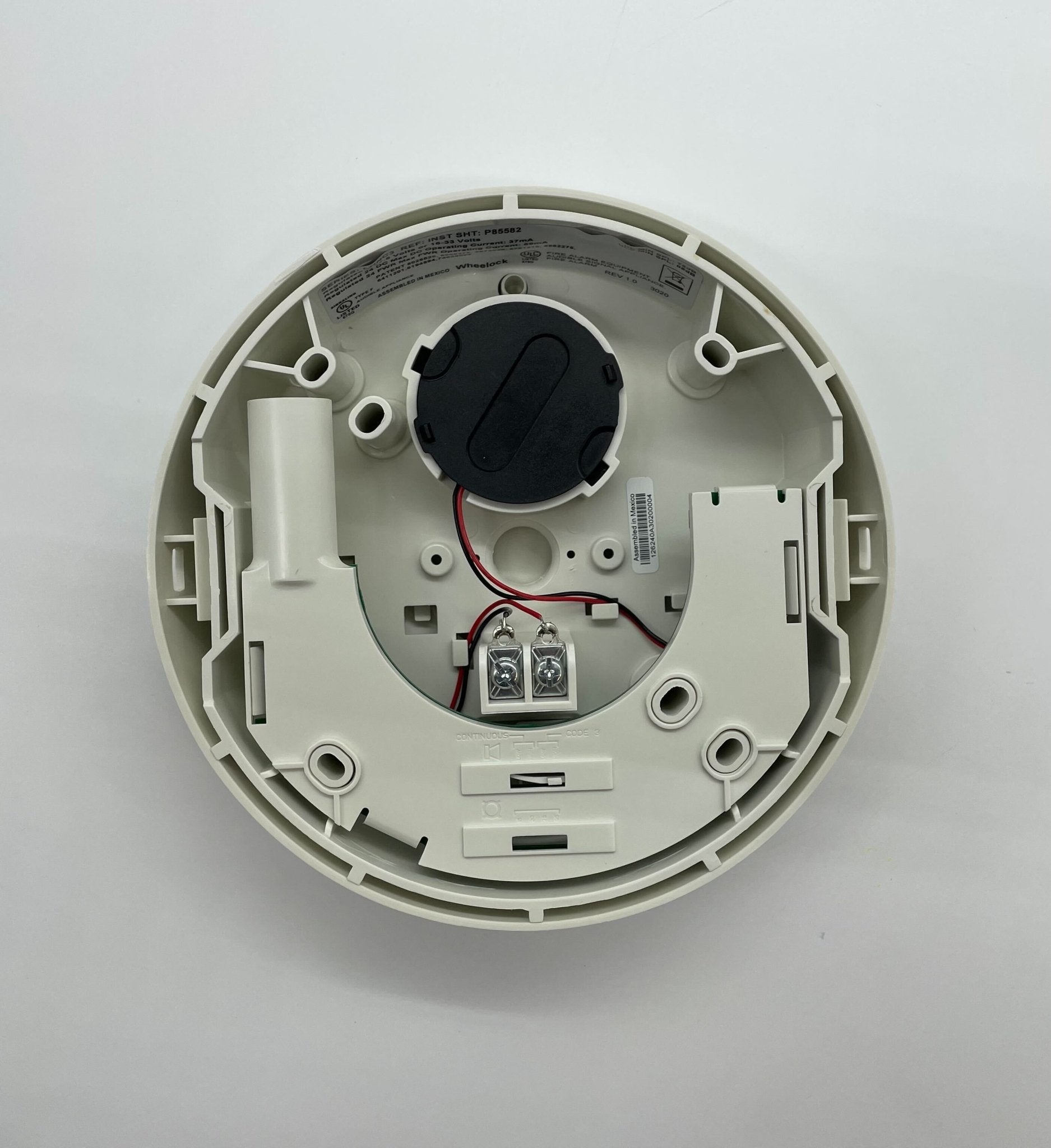 Eaton Wheelock LHNWC3 fire alarm with white cover and warning label, mounted on wall, part of Eaton Wheelock fire alarm system.