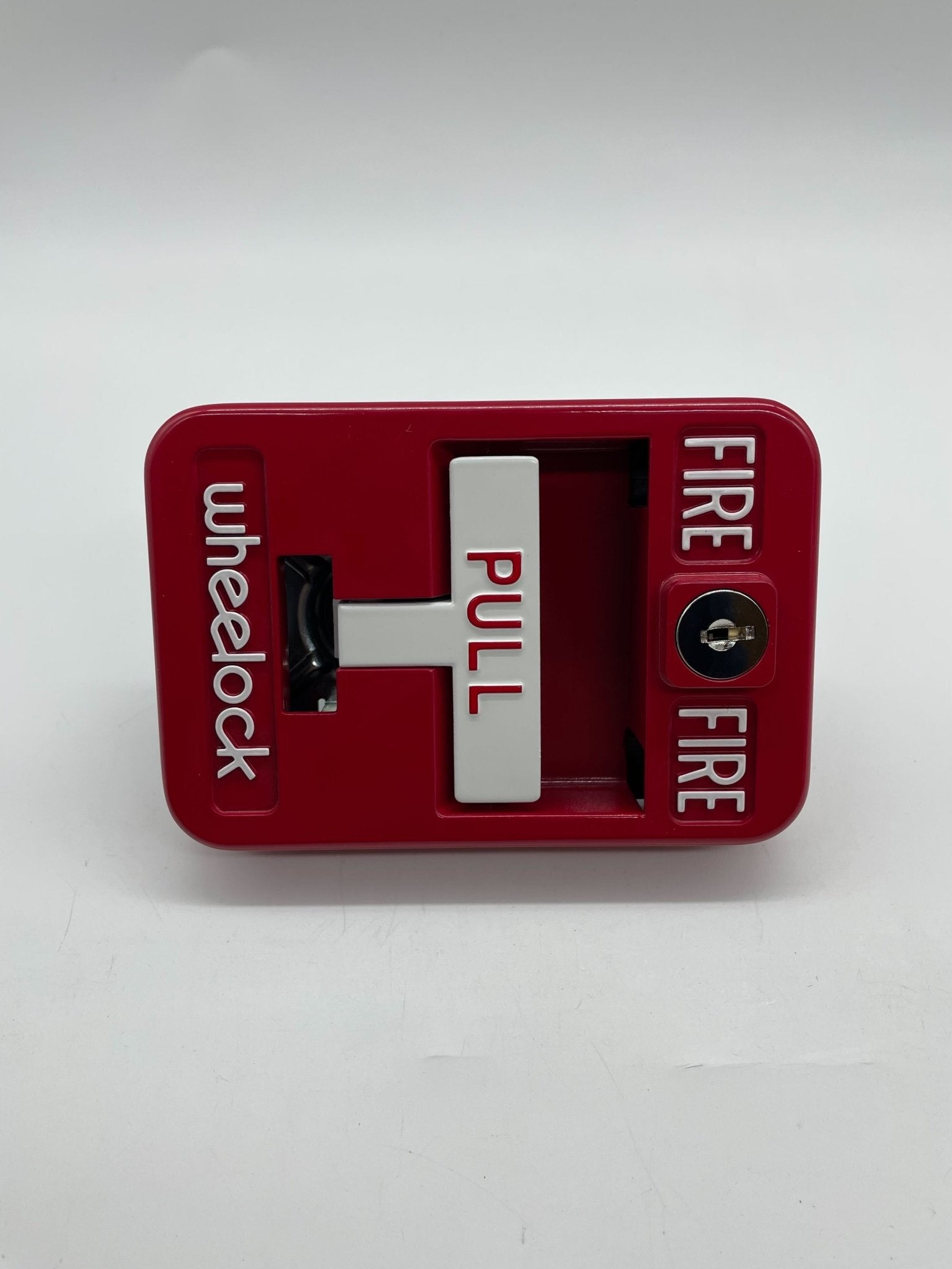 Eaton Wheelock MPS-100 pull station with metal casing and emergency release handle, used for fire alarm systems.