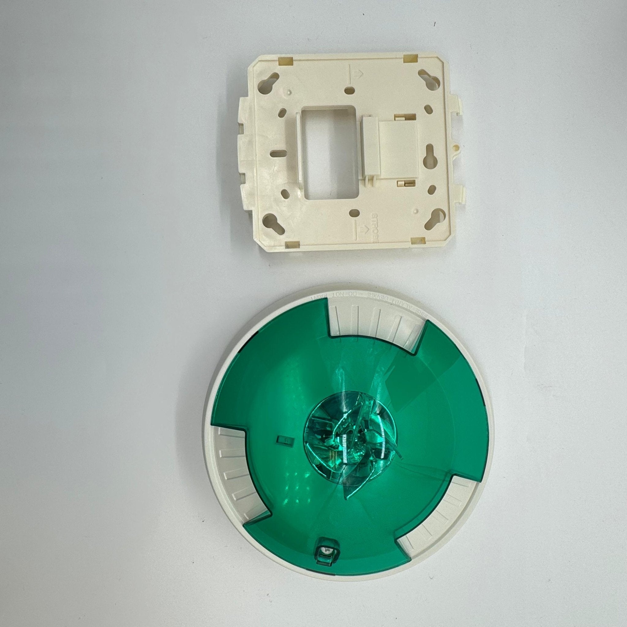 Eaton Wheelock STWC-NG fire alarm with white plastic casing and mounting bracket on a plain background.