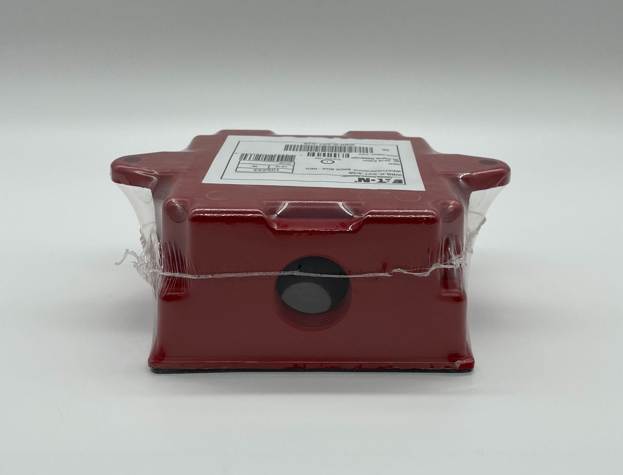 Eaton Wheelock WBB-R-3/4T-3/4B backbox mounted on wall, metal electrical enclosure with knockouts and mounting brackets.