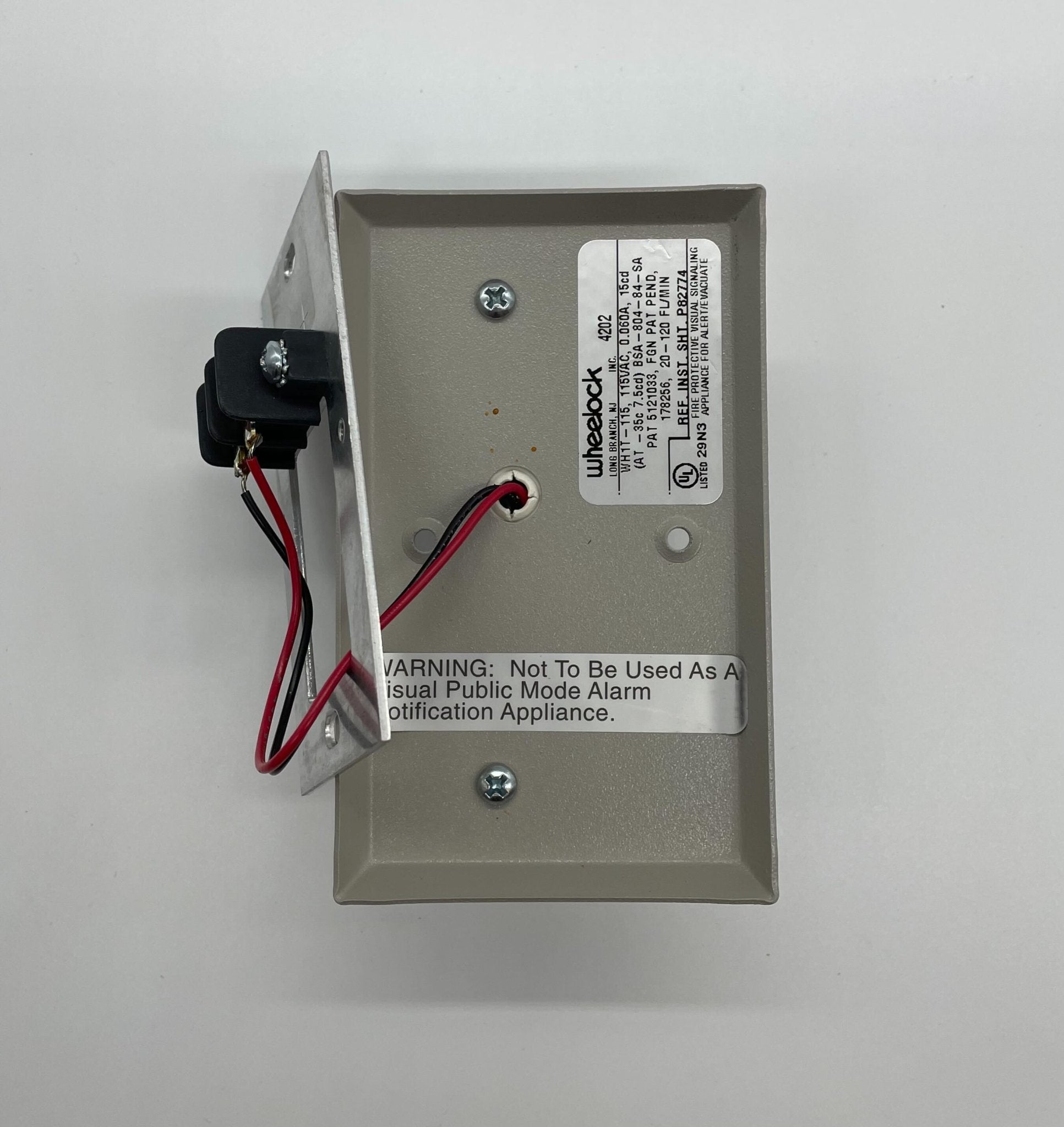 Eaton Wheelock WH1T-115-NS strobe light with white housing and clear lens, mounted for emergency signaling.