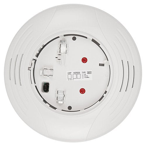 System Sensor B200SR-WH smoke detector mounted on ceiling, white plastic housing, with alarm indicator and testing button visible.