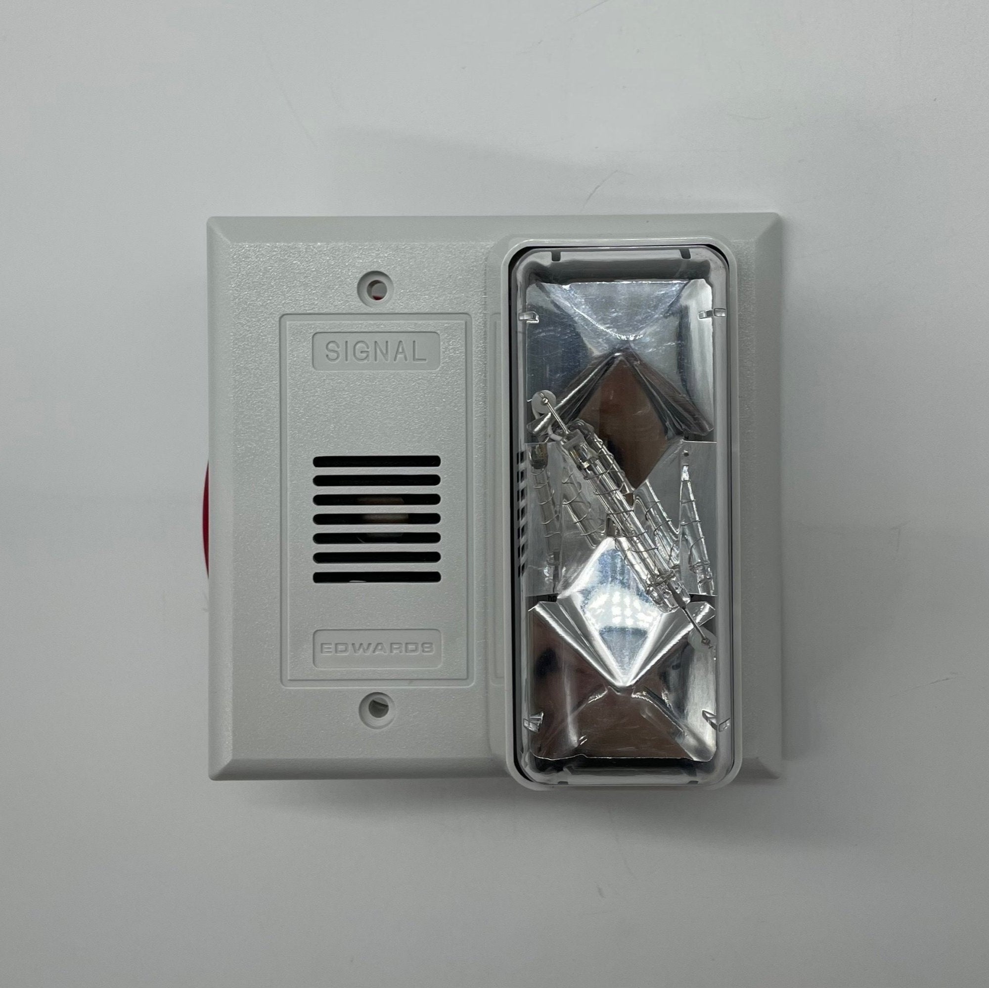 Edwards 7005-G5 fire alarm with detector and wiring, mounted on a wall as part of a building safety system.