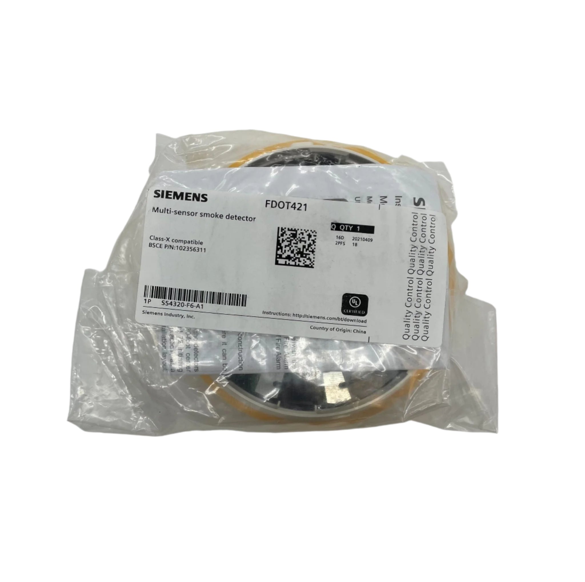 Siemens FDOT421 smoke detector mounted on ceiling, black circular device with sensor and alarm features.