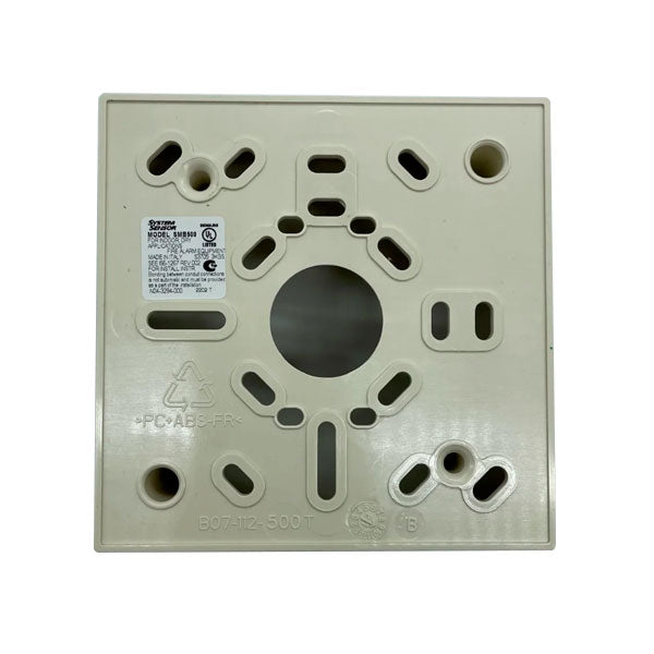 System Sensor SMB500 US smoke detector with alarm and sensor components, mounted on a ceiling in a typical installation setting.